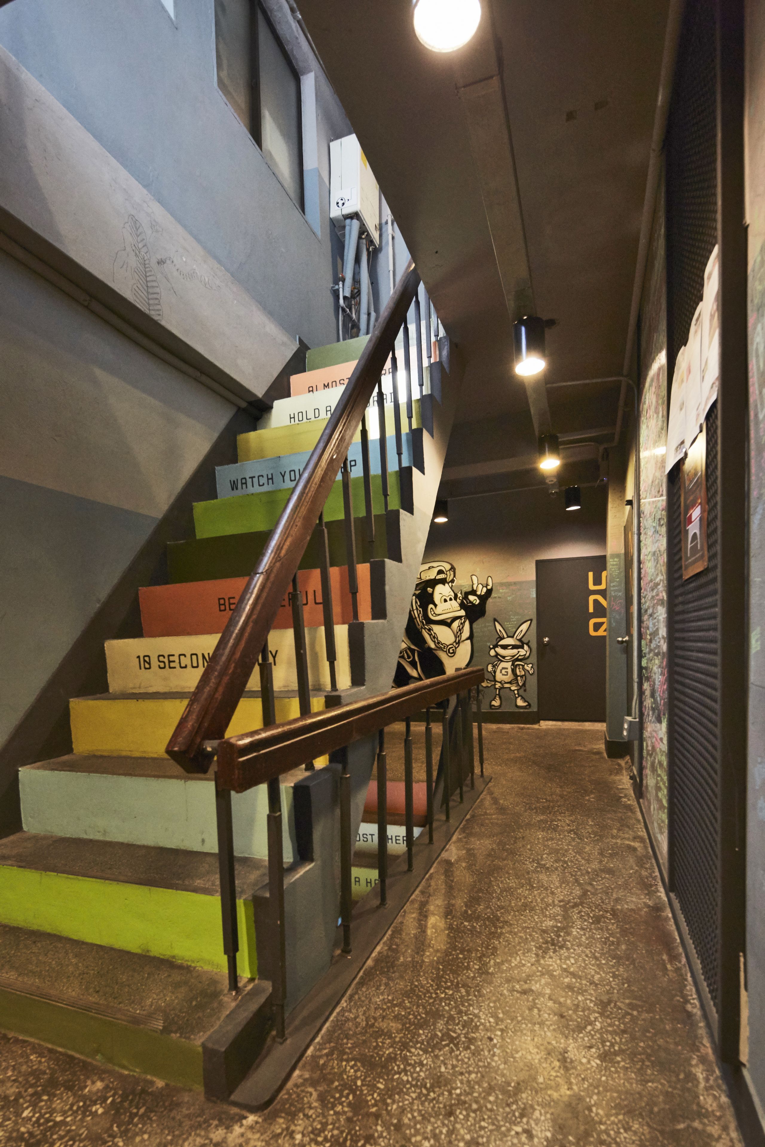 A staircase with colorful steps and a handrail.