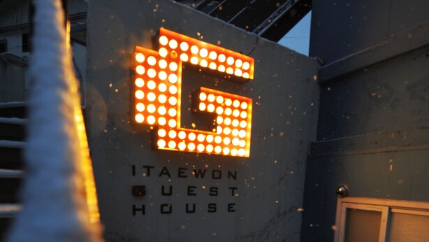 Un edificio con un letrero que dice "ITAEOWON GUEST HOUSE".