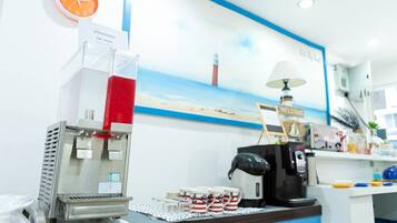 A coffee station with a coffee machine, a red beverage dispenser, and a clock on the wall.