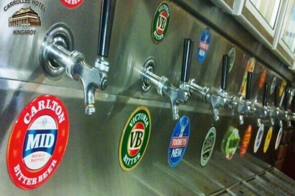 A row of beer taps with various brand labels, including Carlton Mid Bitter and Victoria Bitter.