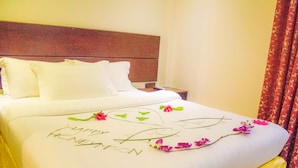 A hotel room with a neatly made bed, a bedside table, and a headboard. - WhiteShell Island Hotel & Spa (Maafushi)