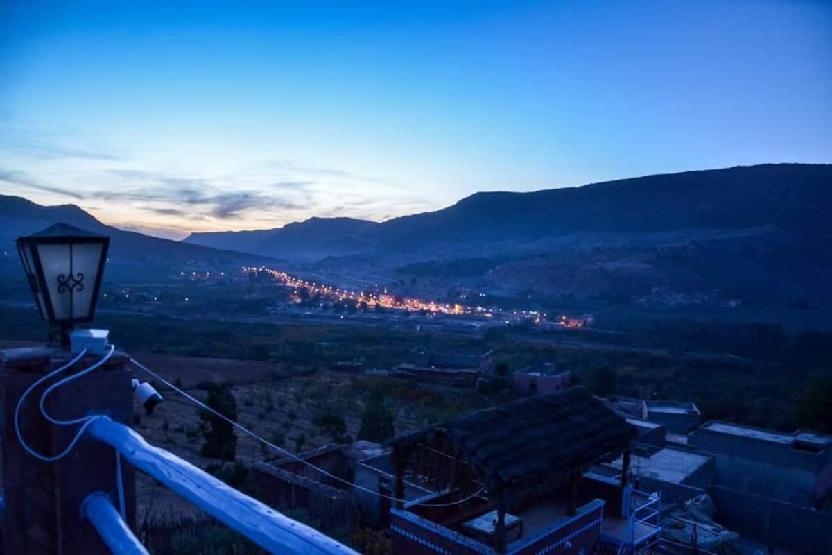 A view of a valley with a long line of lights in the distance, suggesting a town or city.