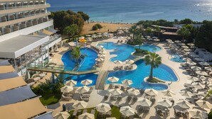 Um resort com várias piscinas, espreguiçadeiras e guarda-sóis.