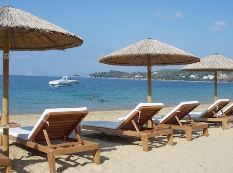 On the beach, white sand, sun loungers, beach umbrellas