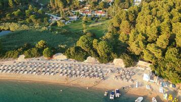 On the beach, white sand, sun-loungers, beach umbrellas