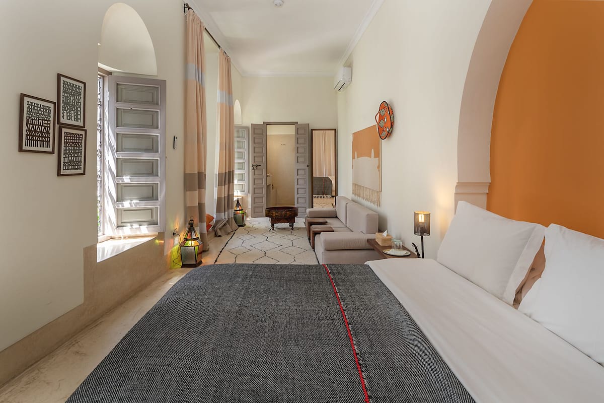 Una habitación de hotel con cama, sofá, una mesita y un adorno en la pared.
