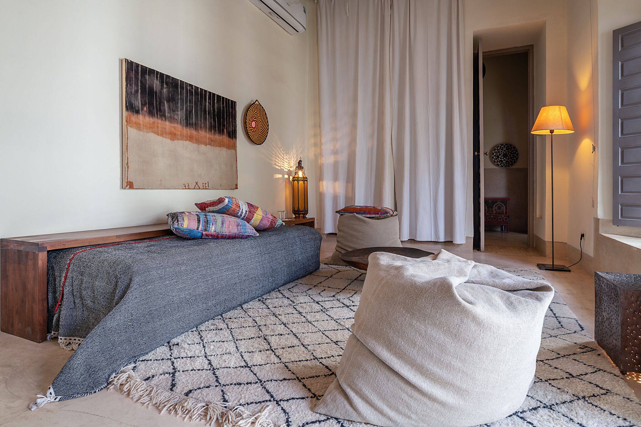 A cozy living room with a sofa, a patterned rug, and a lamp.