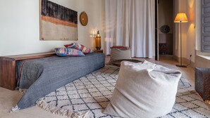 Una sala de estar acogedora con un sofá, un tapete estampado y una lámpara.