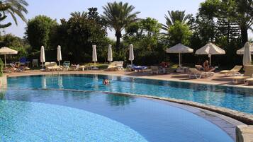 Una piscina techada, una piscina al aire libre de temporada, sombrillas