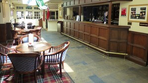 Un restaurant doté de mobilier en bois, d’un bar et d’un comptoir d’accueil.