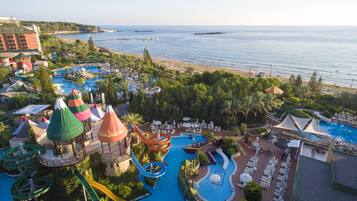 A resort with a large pool area, water slides, and a beach.