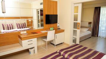 Ein Hotelzimmer mit Bett, Schreibtisch mit Stuhl, Fernseher und Spiegel.