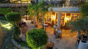 An outdoor courtyard with stone flooring, potted plants, and outdoor seating areas. - AQI Pegasos Royal - All inclusive (Alanya)