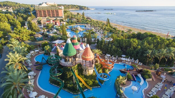 A resort with a large pool, water slides, and a beach. - AQI Pegasos Royal - All inclusive (Alanya)
