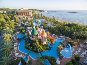 A resort with a large pool, water slides, and a beach. - AQI Pegasos Royal - All inclusive (Alanya)