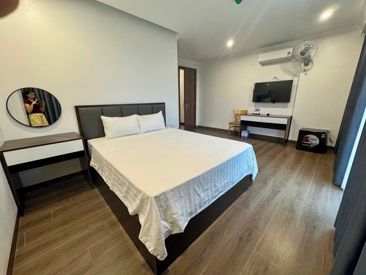 A modern bedroom with a bed, bedside table, and a wall-mounted TV.