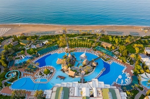 Una piscina cubierta, una piscina al aire libre, sombrillas, tumbonas