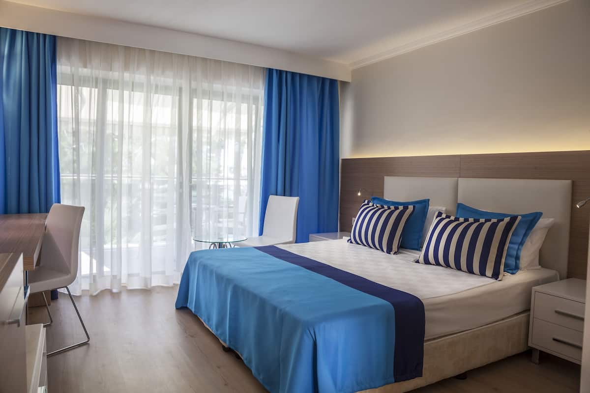 Una habitación de hotel moderna con una cama grande, un escritorio y una silla.