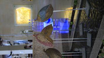 A dining area with a high ceiling and hanging decorative elements.