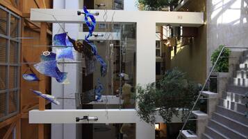 A modern building with a glass facade, interior staircases, and hanging glass sculptures.