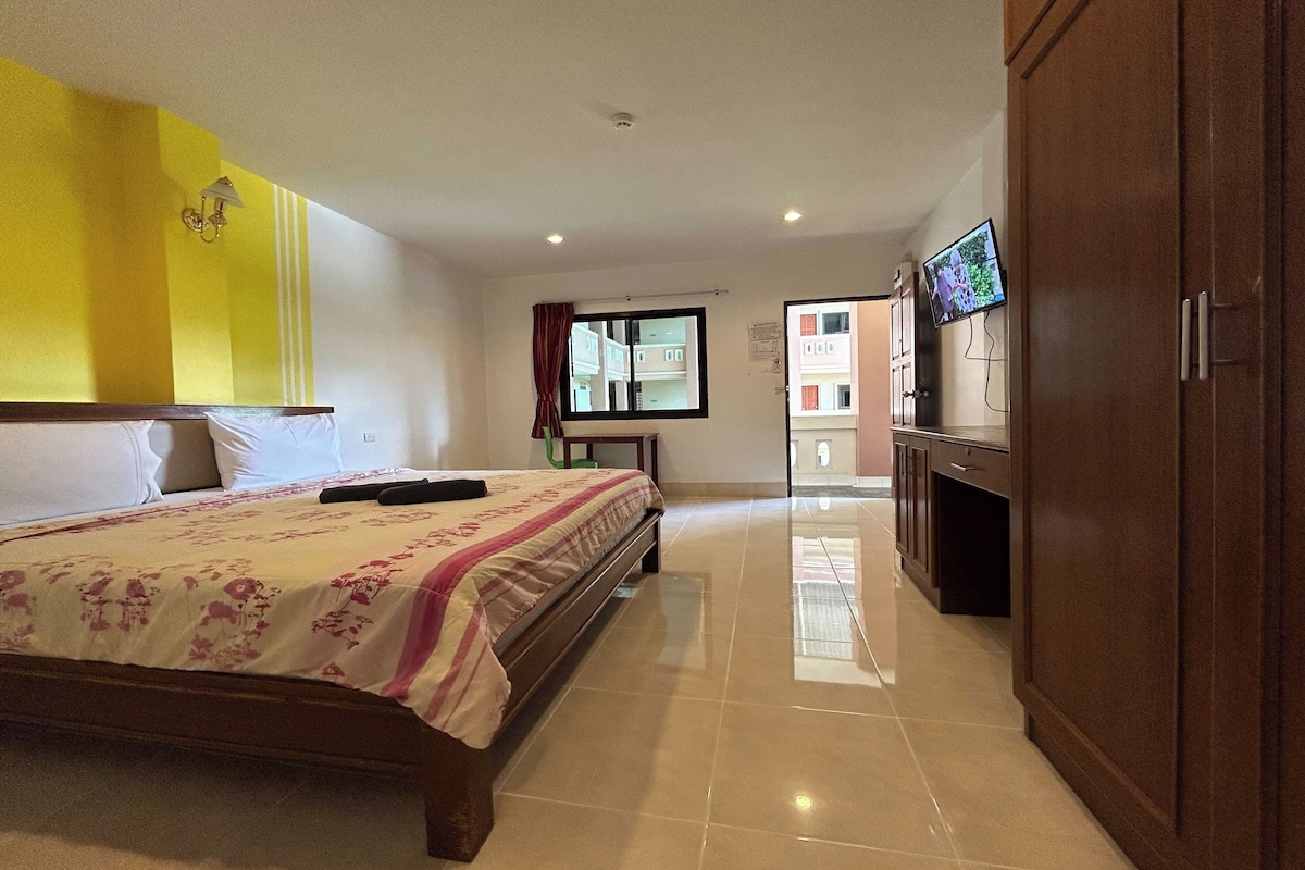 A hotel room with a bed, a television, and a wardrobe.