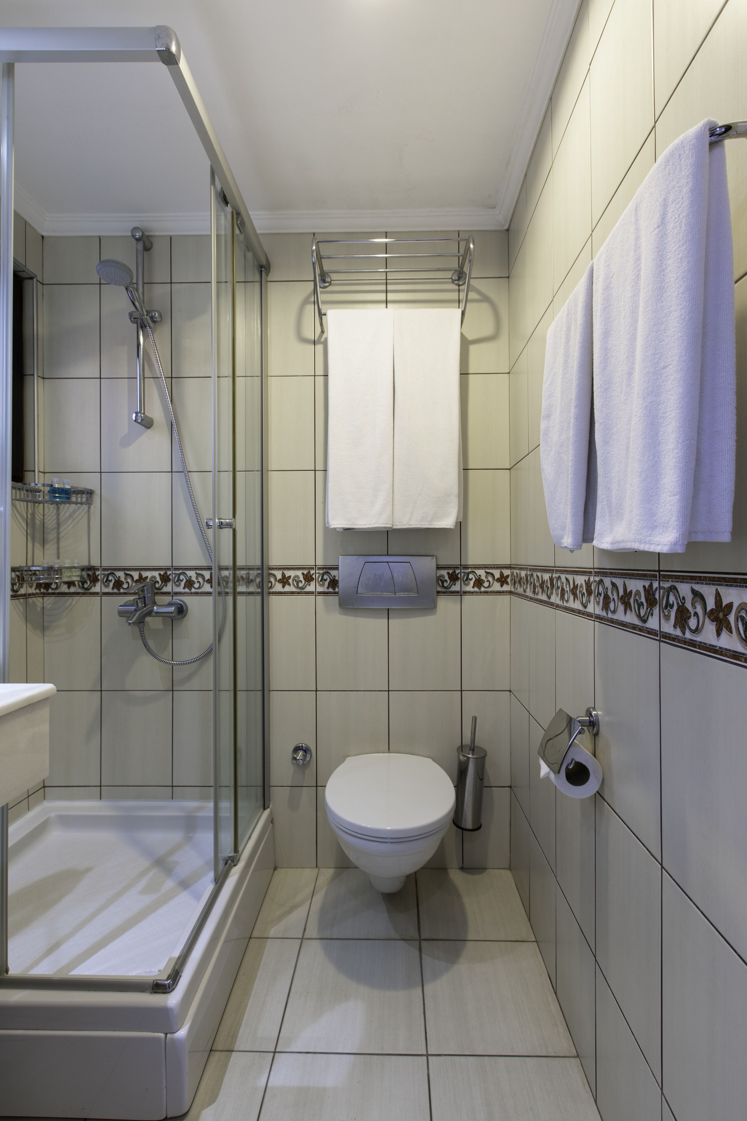 A modern bathroom with a glass-enclosed shower, a toilet, and a sink.