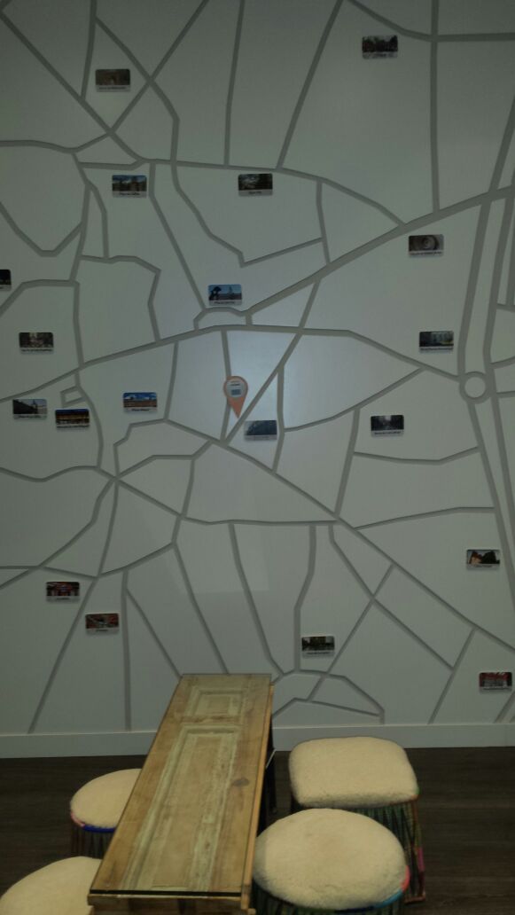 A room with a map wall, a wooden table, and cushioned seating.
