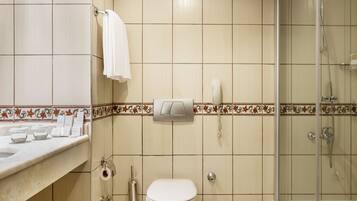 A bathroom with a toilet, sink, and shower.