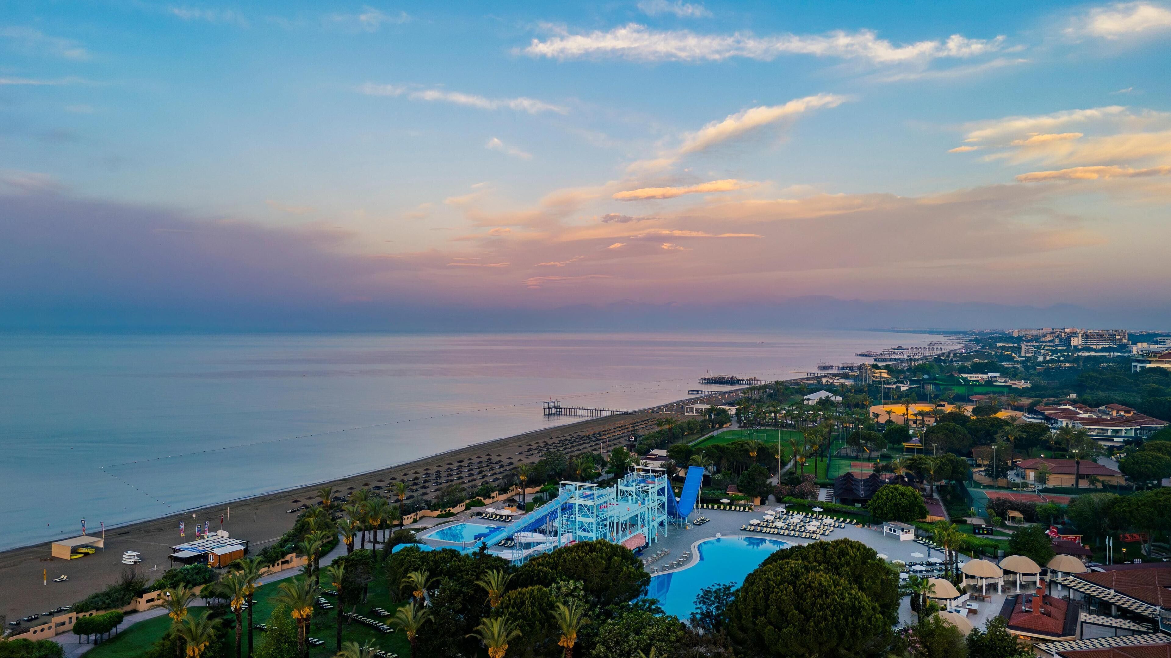 Un resort con una piscina grande, un tobogán de agua y una zona de playa.