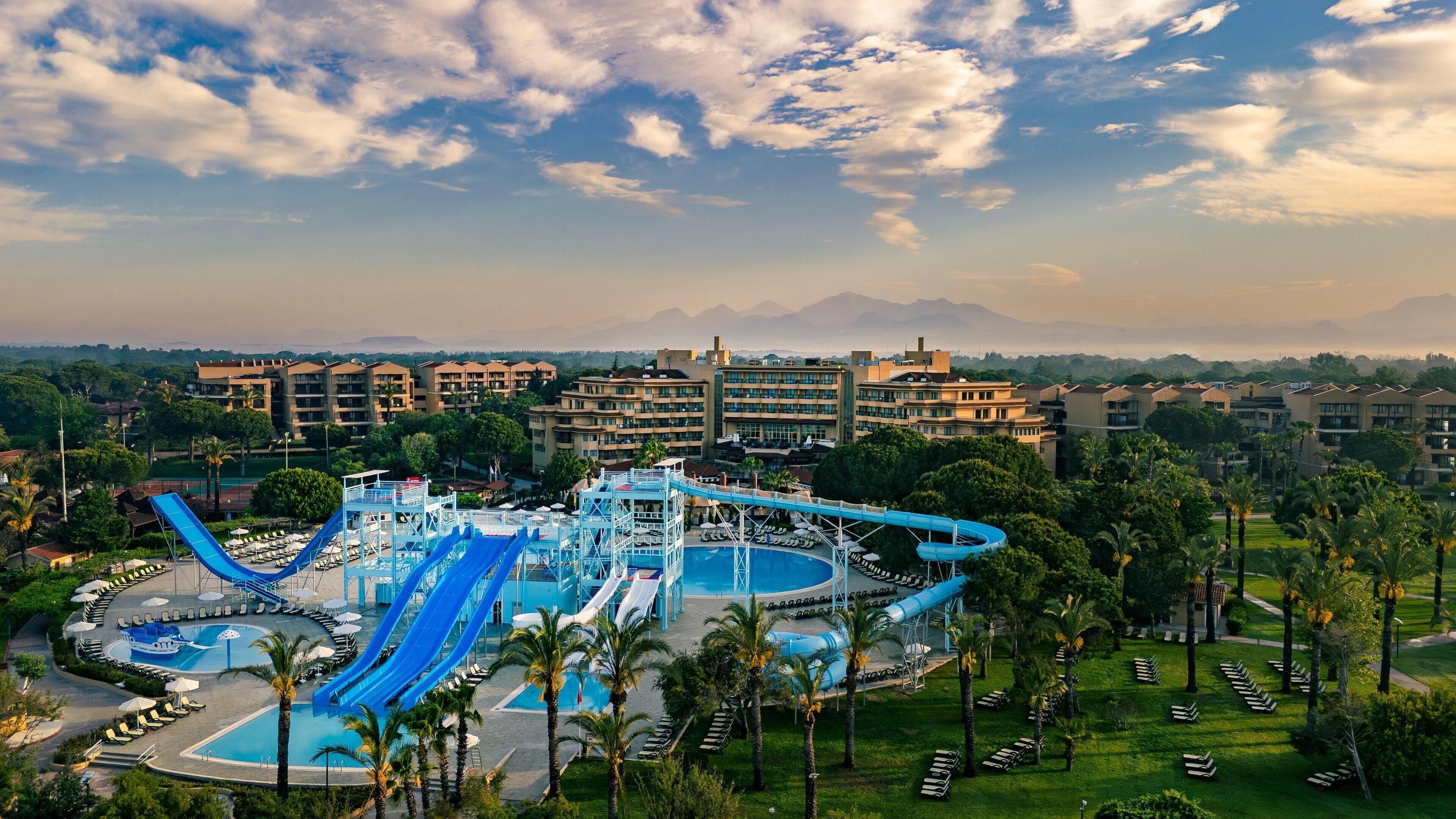A resort with multiple swimming pools, water slides, and a large water park area.
