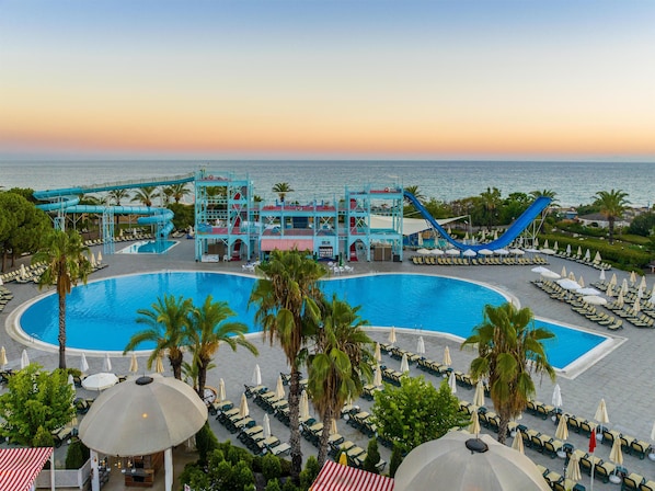 Een binnenzwembad, een buitenzwembad en parasols bij het zwembad