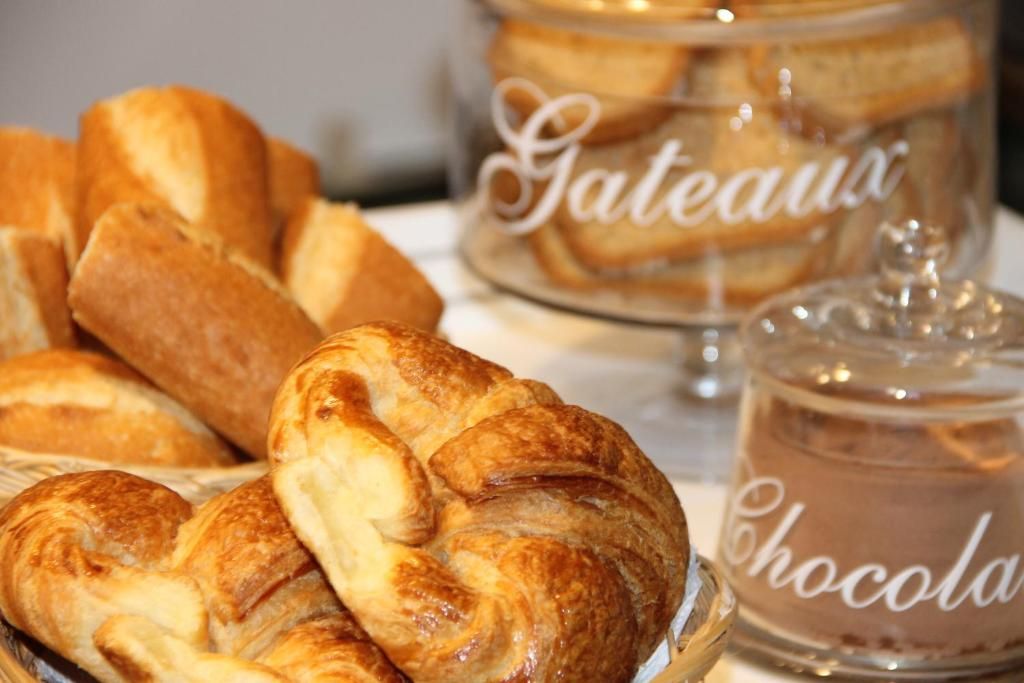 Esposizione di dolci, tra cui croissant, e un barattolo con l'etichetta 'Gateaux' e un altro con l'etichetta 'Cioccolato'.