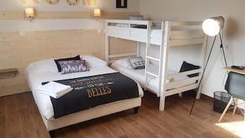 A room with a bunk bed, a desk with a chair, a lamp, and a wall-mounted sign reading "ROOM 1".