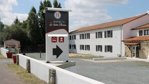 A hotel sign with a directional arrow, indicating the hotel's location. - Le Sainte Florence (Essarts en Bocage)