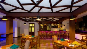 A restaurant with wooden tables and chairs, a bar area, and a high ceiling with exposed beams. - Heaven Seven Nuwara Eliya (Nuwara Eliya)
