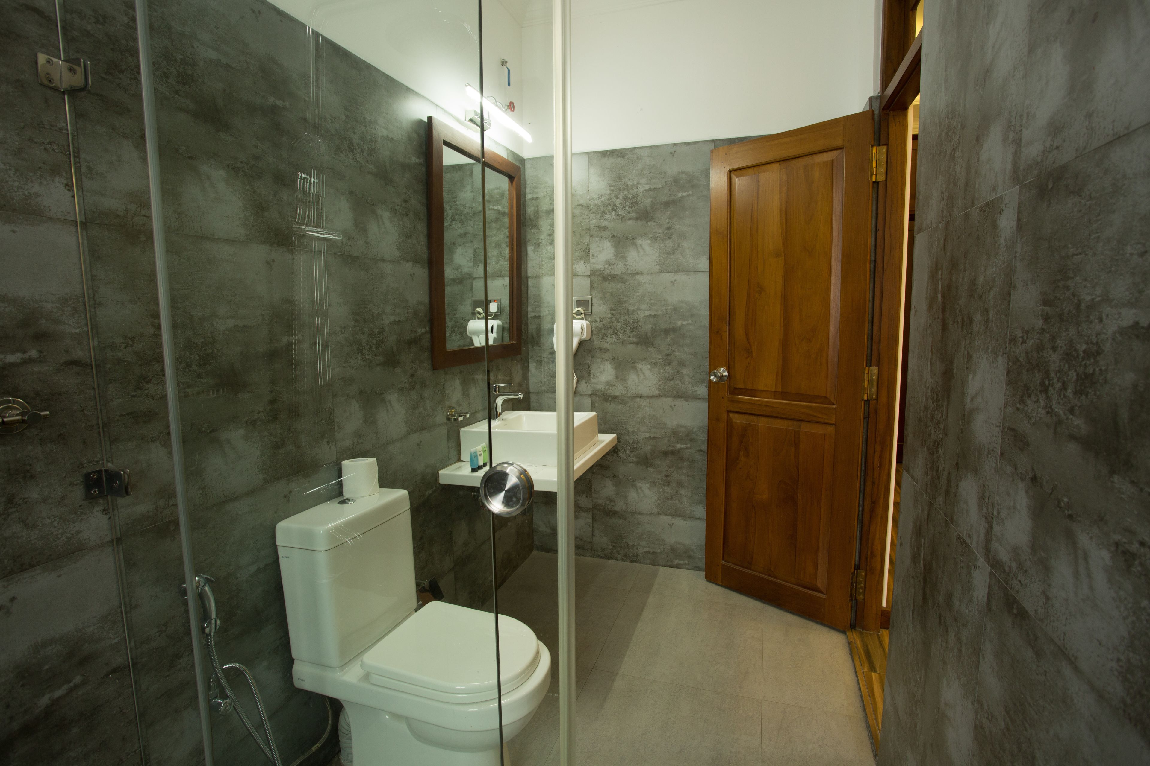 A bathroom with a toilet, sink, and shower.