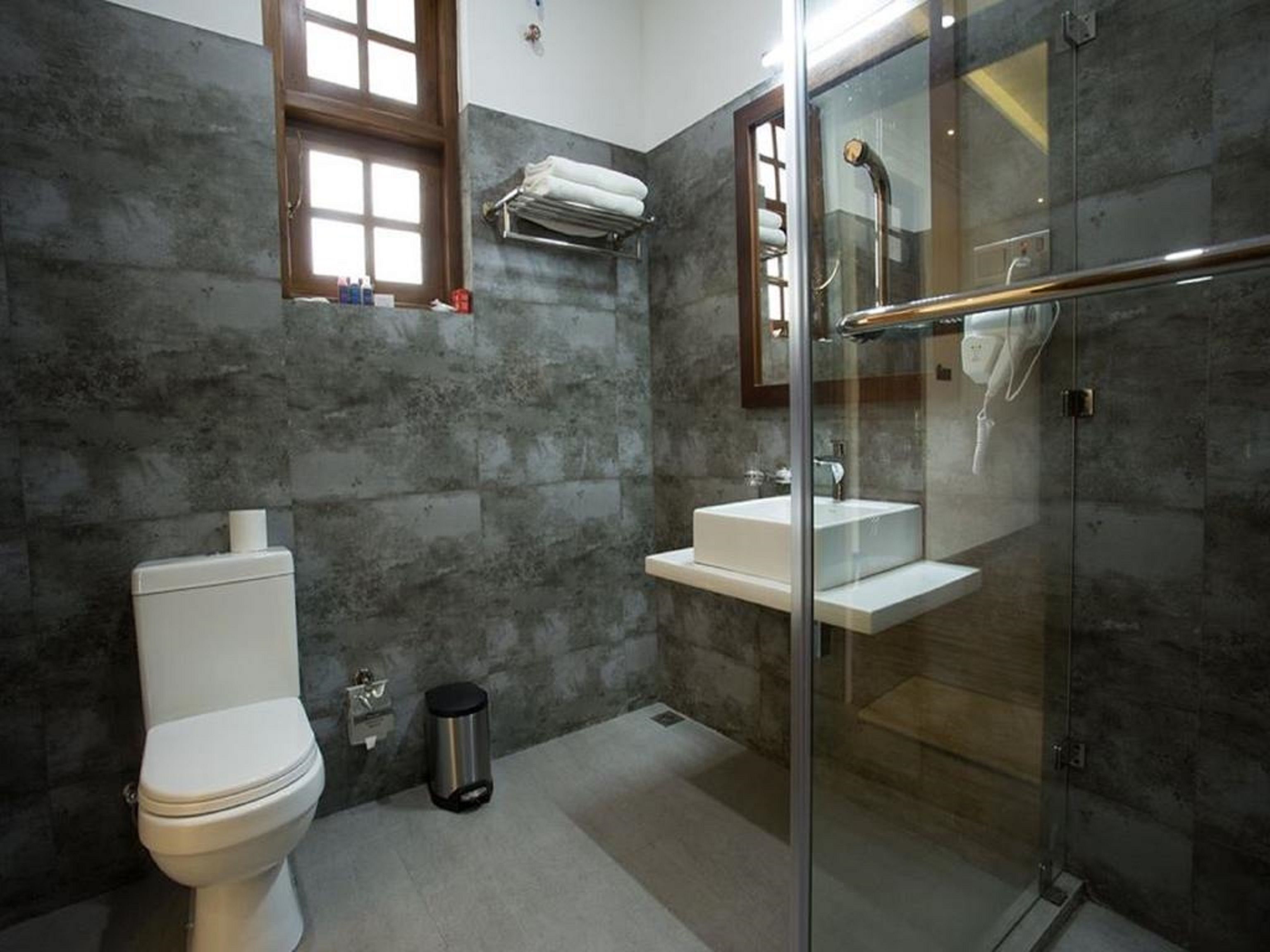 A modern bathroom with a toilet, sink, and glass-enclosed shower.