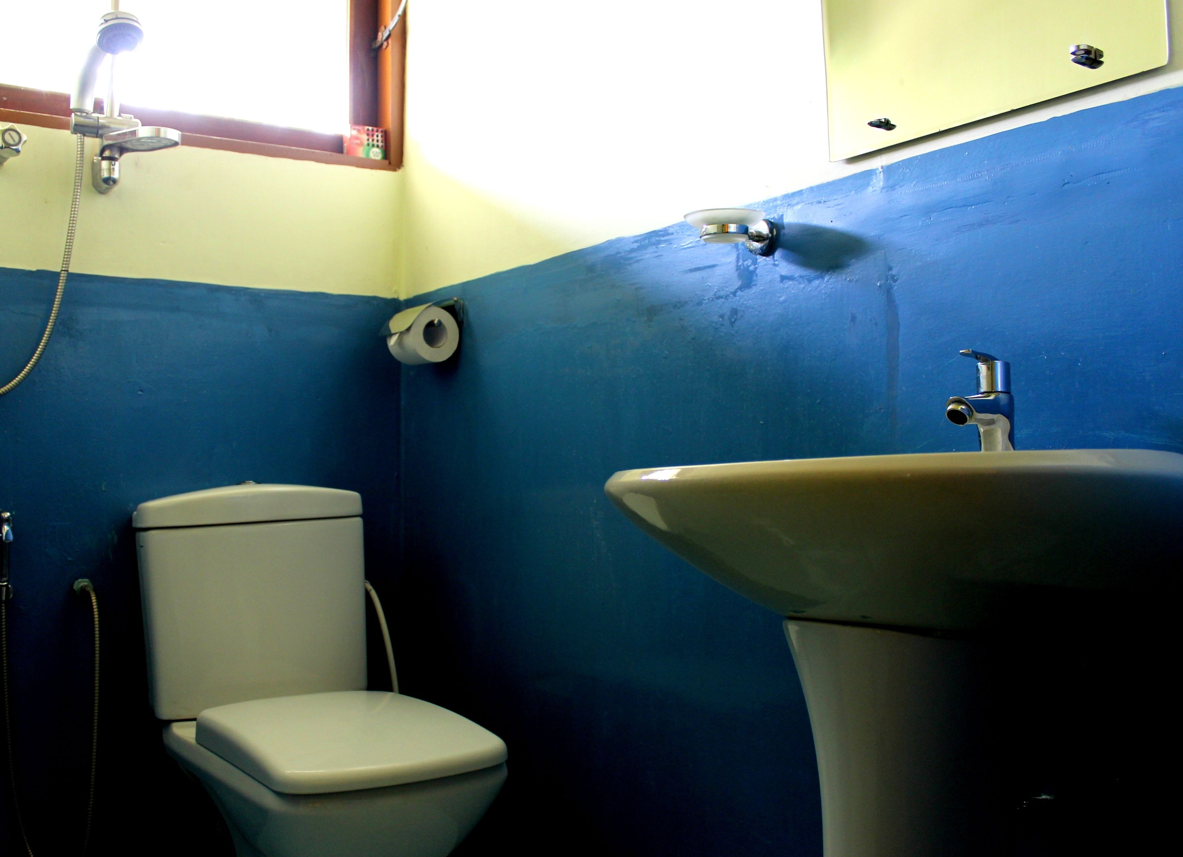 A bathroom with a toilet, sink, and shower.