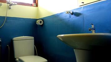 A bathroom with a toilet, sink, and shower.