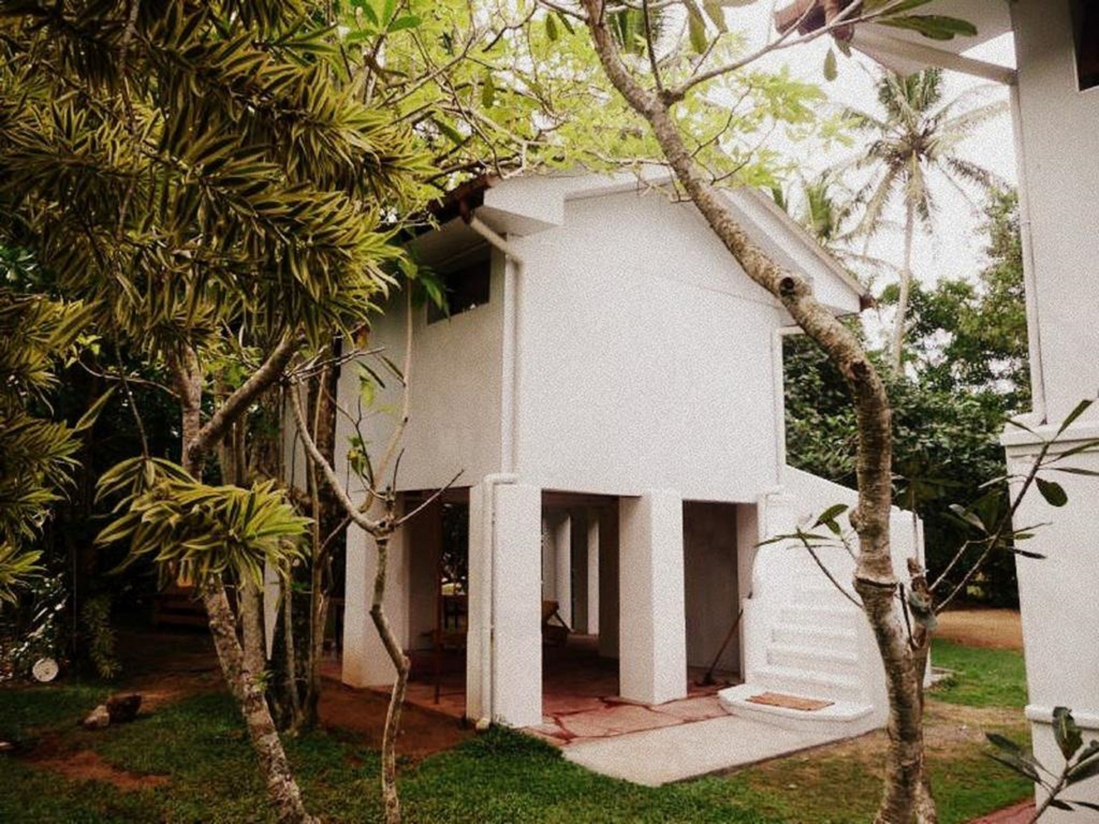 Um edifício branco com telhado plano e um pequeno alpendre.