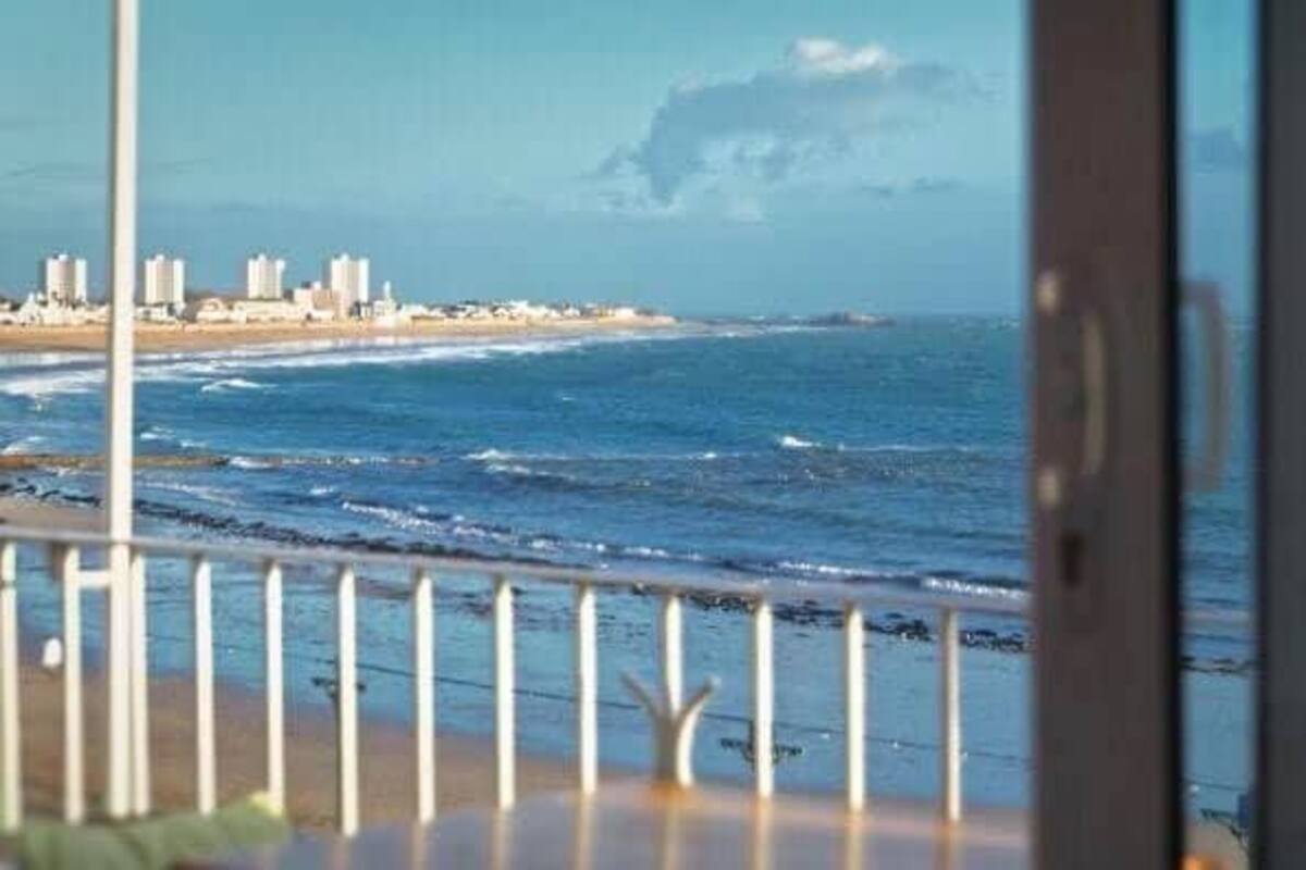 Vista del océano desde un balcón con barandilla.
