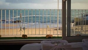 A room with a view of the beach and ocean through a window with metal bars. - De L'Etang Jersey (St. Helier)
