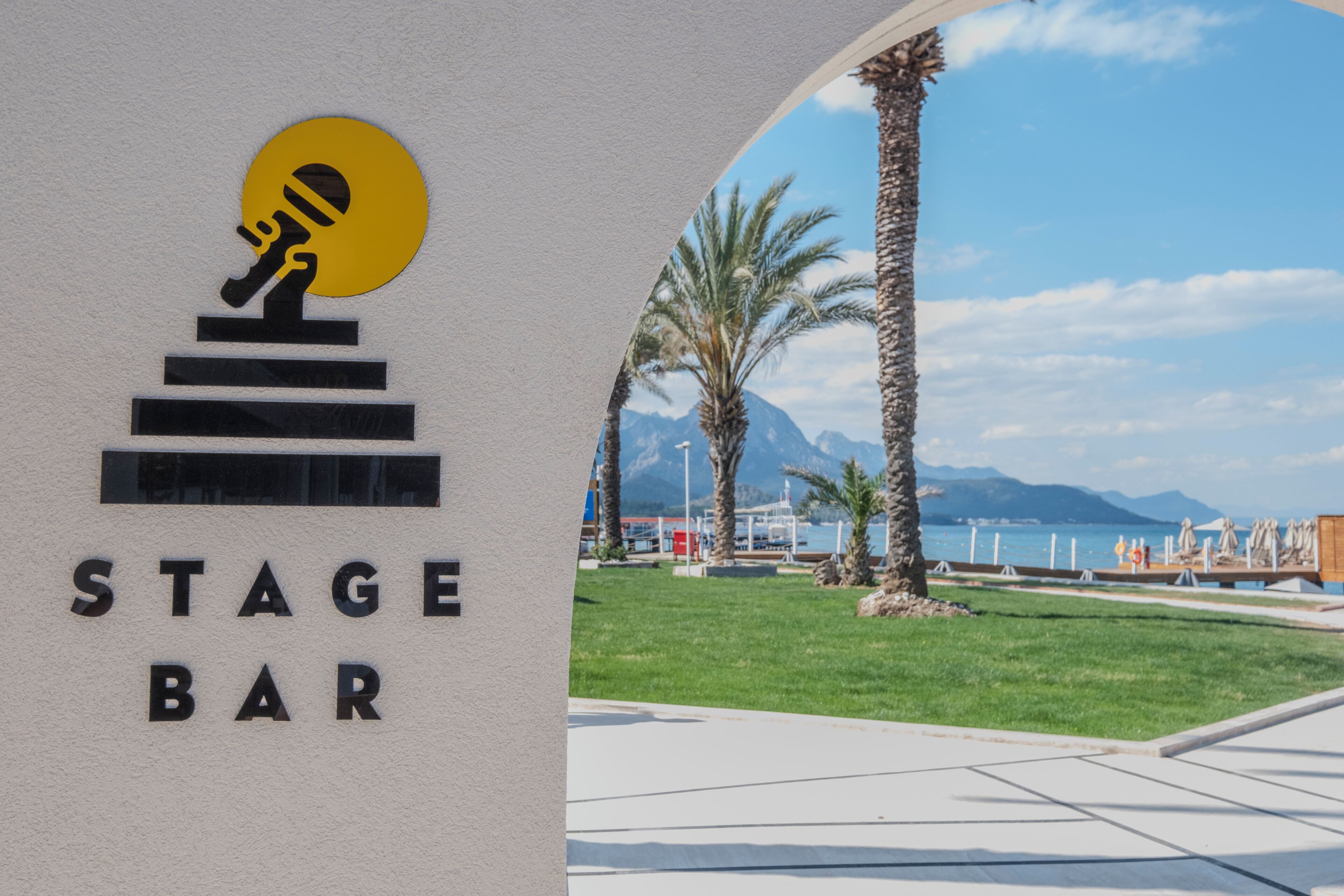 Une enseigne indiquant « BAR-SCÈNE », avec un logo représentant un microphone et une scène.