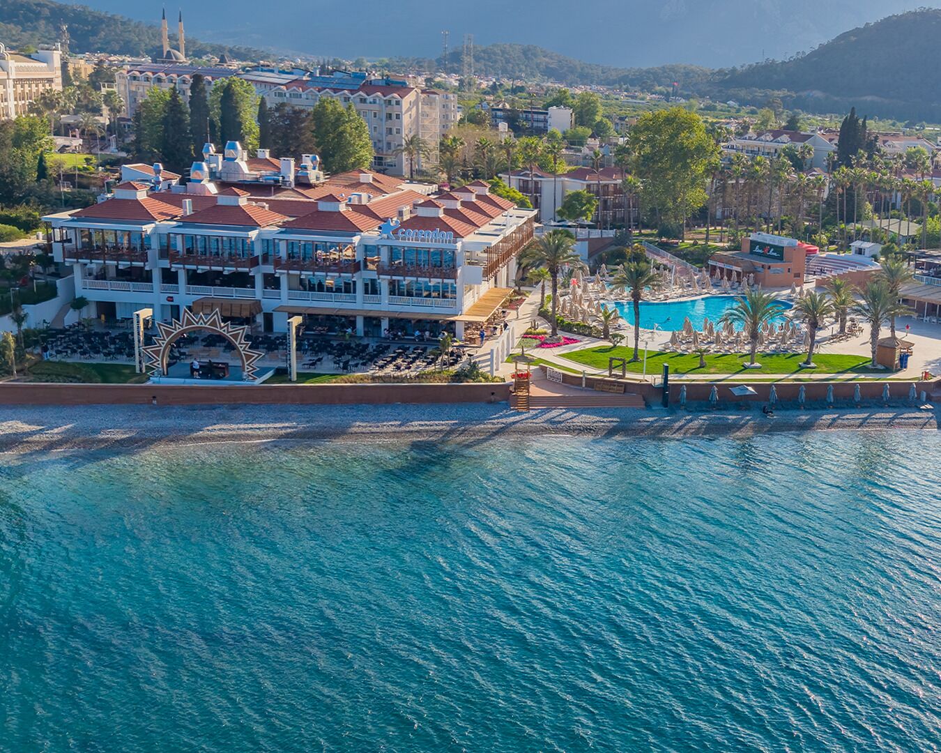 Un hotel frente al mar con piscina, terraza y vistas al océano.