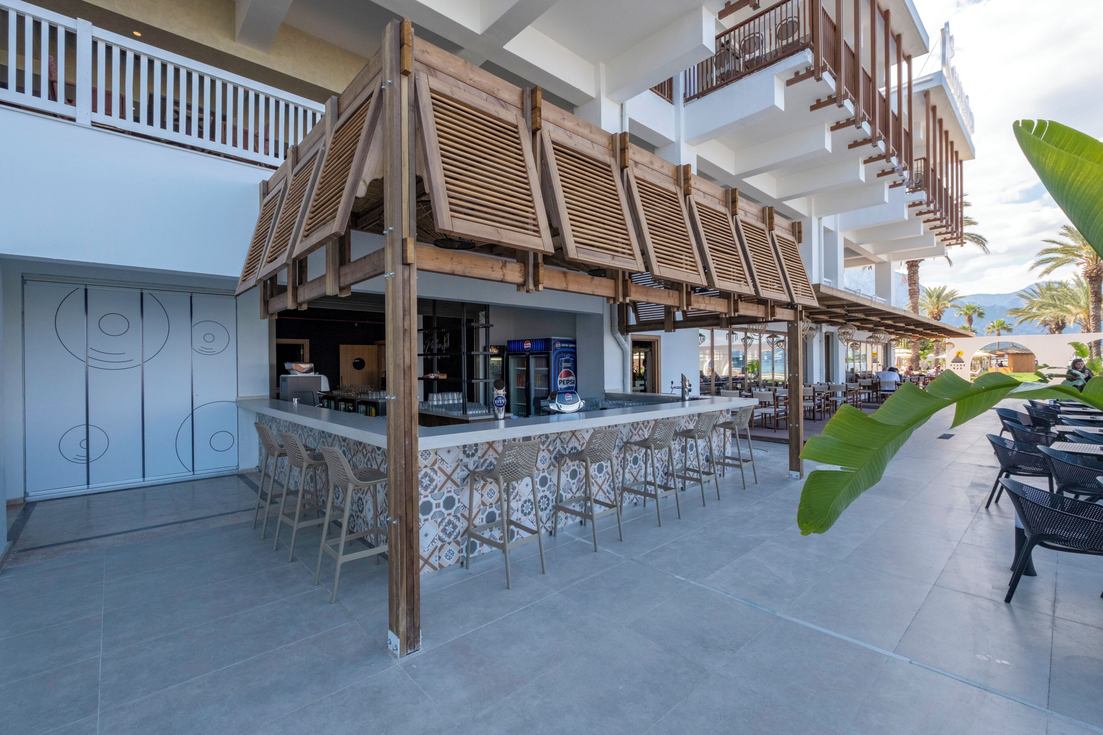 A bar area with a counter, bar stools, and a seating area with tables and chairs.