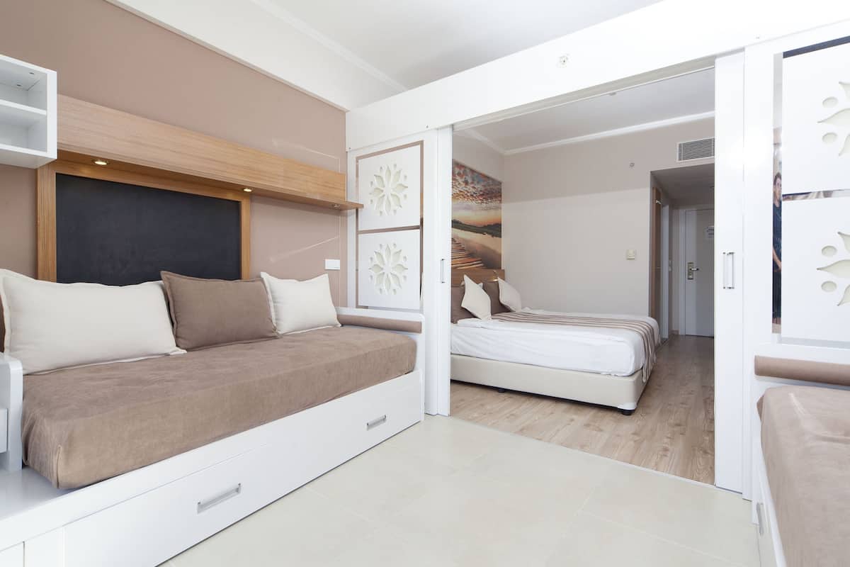 Une chambre moderne avec un canapé-lit, un lit séparé et un panneau décoratif mural.
