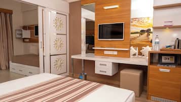 A hotel room with a bed, a TV, a desk, and a wardrobe.