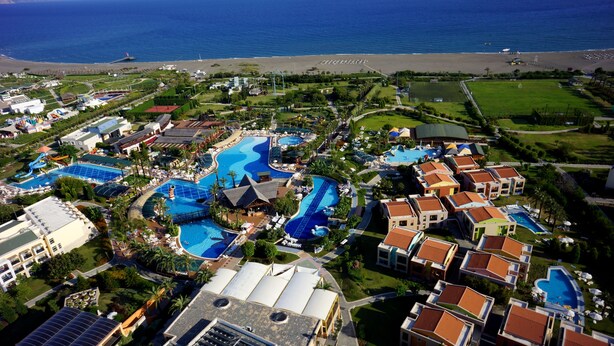 Ein Resort mit mehreren Schwimmbecken, Blick auf den Strand und verschiedenen Hotelgebäuden.