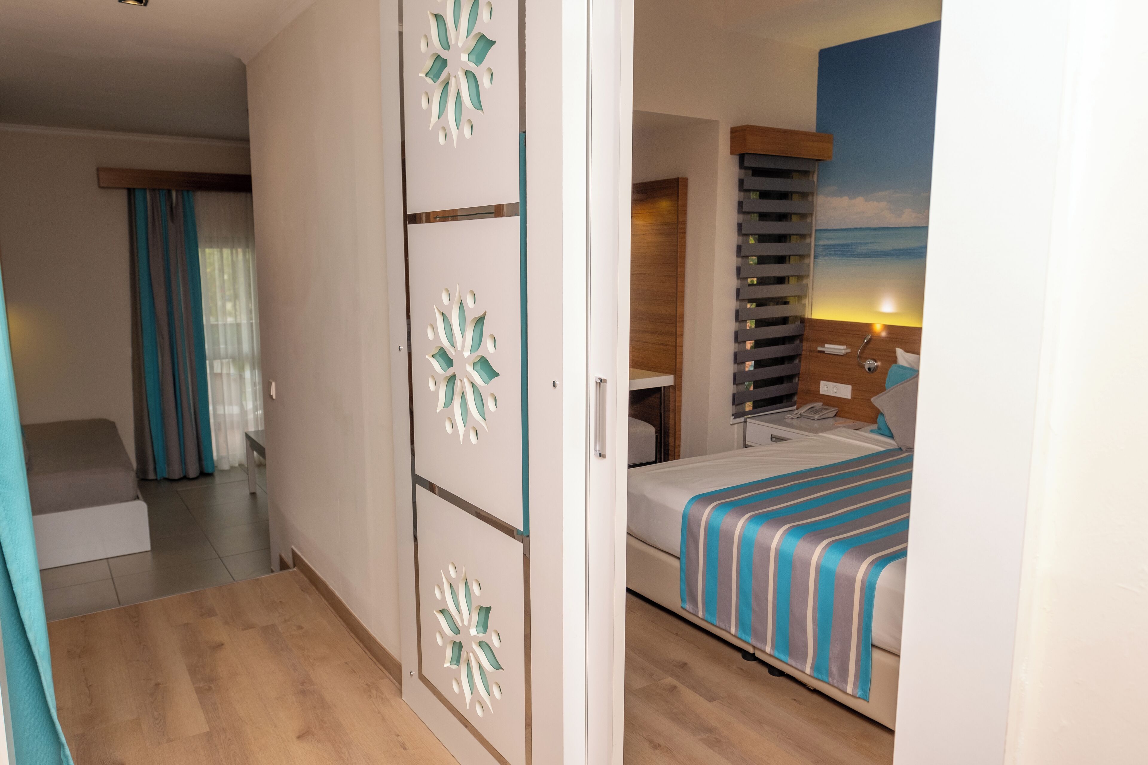 Una habitación de hotel con cama, escritorio y vista al océano.