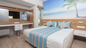 Ein modernes Schlafzimmer mit einem großen Bett, einem hölzernen Kopfteil, einem Wandgemälde mit Strandmotiv, einem Schminktisch mit Spiegel und einem kleinen Schreibtisch.